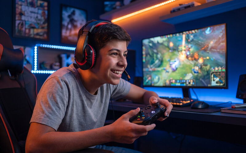 Adolescente jogando online no quarto, de headset